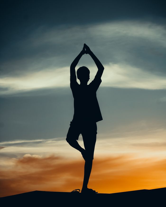 The Art of Drawing Readers In: Your attractive post title goes here Silhouette of a person doing yoga against a colorful sunset sky, highlighting tranquility and mindfulness.