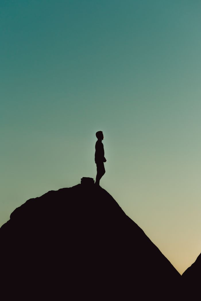 Crafting Captivating Headlines: Your awesome post title goes here A lone figure stands silhouetted on a mountain peak, backlit by the warm, fading hues of sunset.